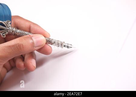 écriture manuelle de l'homme avec stylo plume sur fond blanc Banque D'Images