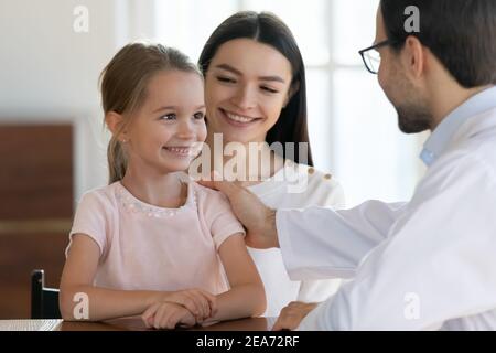 Un médecin de sexe masculin applaudisse une petite patiente lors d'une consultation à l'hôpital Banque D'Images