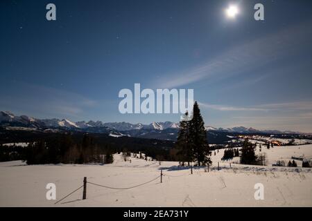 Nuit, ciel étoilé sur un paysage de montagne d'hiver Banque D'Images