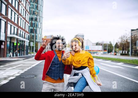 Jeune couple avec smartphone pour la vidéo des médias sociaux en plein air dans la rue. Banque D'Images