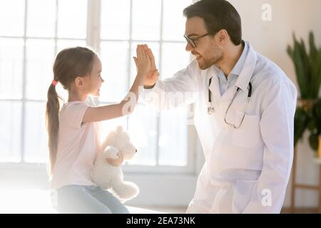 Un médecin de sexe masculin heureux joue avec une petite fille Banque D'Images