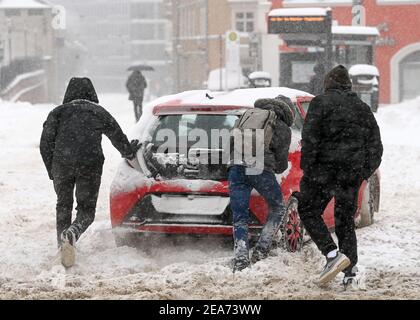 Saale, Allemagne. 08 février 2021. 08 février 2021, Saxe-Anhalt, Halle (Saale): Les passants poussent une voiture dans le centre de Halle/Saale. De fortes chutes de neige entraînent des obstacles considérables sur les routes, les chemins de fer et les sentiers. Photo: Hendrik Schmidt/dpa-Zentralbild/ZB crédit: dpa Picture Alliance/Alay Live News Banque D'Images