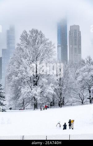 Personnes construisant un bonhomme de neige dans Central Park pendant une tempête de neige. Banque D'Images