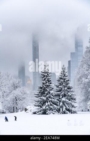 Personnes construisant un bonhomme de neige dans Central Park pendant une tempête de neige. Banque D'Images