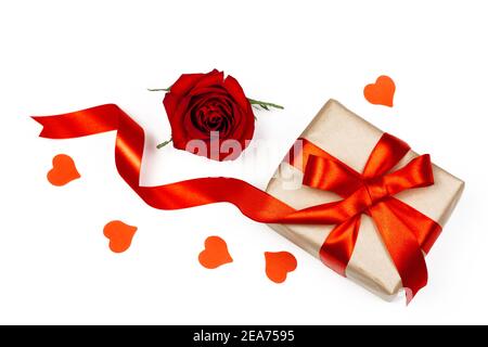 Boîte cadeau avec ruban rouge, petit coeur rouge et rose rouge sur fond blanc. Vacances et le jour romantique de Valentin plat. Banque D'Images