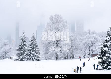 Personnes construisant un bonhomme de neige dans Central Park pendant une tempête de neige. Banque D'Images