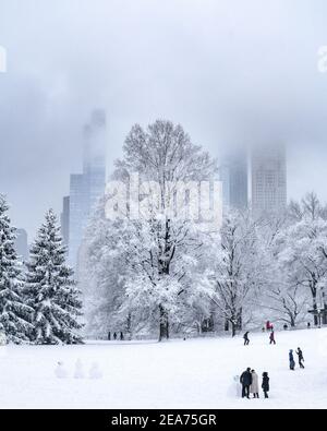 Personnes construisant un bonhomme de neige dans Central Park pendant une tempête de neige. Banque D'Images