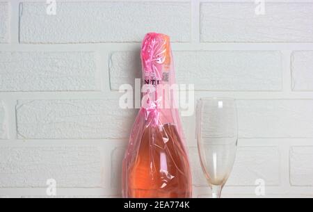 Kiev, Ukraine, 7 février 2020. Bouteille de Prosecco Canti rose et verre de champagne sur fond de mur en brique blanche. Produits alcoolisés pour le ladi Banque D'Images