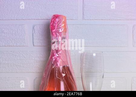 Kiev, Ukraine, 7 février 2020. Bouteille de Prosecco Canti rose et verre de champagne sur fond de mur en brique blanche. Produits alcoolisés pour le ladi Banque D'Images