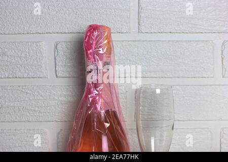 Kiev, Ukraine, 7 février 2020. Bouteille de Prosecco Canti rose et verre de champagne sur fond de mur en brique blanche. Produits alcoolisés pour le ladi Banque D'Images