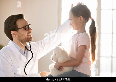 Sourire médecin encourager petite fille enfant patient Banque D'Images