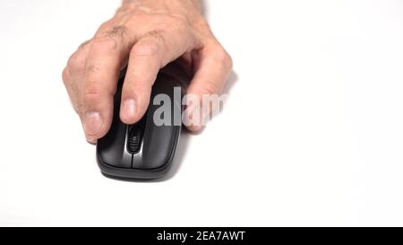 Isolé sur un arrière-plan blanc. Une main d'un vieil homme tient une souris d'ordinateur sans fil sur la table. Cliquez et déplacez Banque D'Images