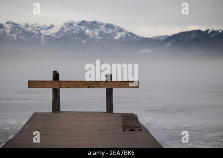 Nez-pièce en bois barré sur lac gelé dans la haute-Bavière avec Alpes en arrière-plan en hiver avec de la neige Banque D'Images