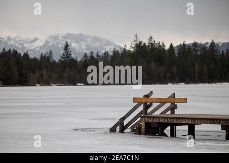 Nez-pièce en bois barré sur lac gelé dans la haute-Bavière avec Alpes en arrière-plan en hiver avec de la neige Banque D'Images