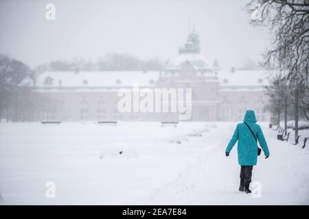 Bad Oeynhausen, Allemagne. 08 février 2021. Une femme marche dans le parc thermal enneigé en face du Kaiser-Palais. Après le début de l'hiver, le grand froid arrive en Rhénanie-du-Nord-Westphalie. Selon les prévisions du service météorologique allemand à partir de lundi, les températures ne s'élèveront pas au-dessus de zéro degré même pendant la journée jusqu'au week-end (13./14.02.2021). Crédit : Lino Mirgeler/dpa/Alay Live News Banque D'Images