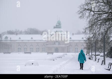 Bad Oeynhausen, Allemagne. 08 février 2021. Une femme marche dans le parc thermal enneigé en face du Kaiser-Palais. Après le début de l'hiver, le grand froid arrive en Rhénanie-du-Nord-Westphalie. Selon les prévisions du service météorologique allemand à partir de lundi, les températures ne s'élèveront pas au-dessus de zéro degré même pendant la journée jusqu'au week-end (13./14.02.2021). Crédit : Lino Mirgeler/dpa/Alay Live News Banque D'Images