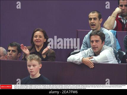 © Laurent Zabulon/ABACA. 55880-9. Paris-France, le 10 février 2004. Nouvelle sensation de tennis, née en Russie, adolescente française Tatiana Golovin a marqué sa deuxième victoire aux dépens d'Anna Smashnova-Pistolesi lorsqu'elle a sauvé deux points de match pour mener 1-6, 7-5, 3-1 lorsque la sixième graine israélienne épuisée a pris sa retraite avec des crampes musculaires du 12ème Open gaz de France à 585,000 dollars au Stade Pierre de Coubertin. On voit ici sa mère Ludmila, son entraîneur Pierre Cherret (ancien entraîneur de Cédric Pioline) et Xavier Moreau (chemise bleue) son entraîneur physique. Banque D'Images