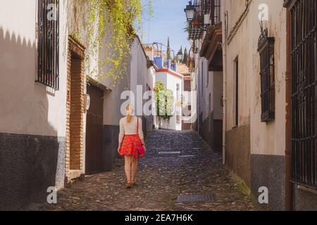 Une jeune femme blonde touristique explore les rues pavées pittoresques et étroites de la vieille ville (Albaicin ou quartier arabe) Grenade, Espagne, Andalousie. Banque D'Images