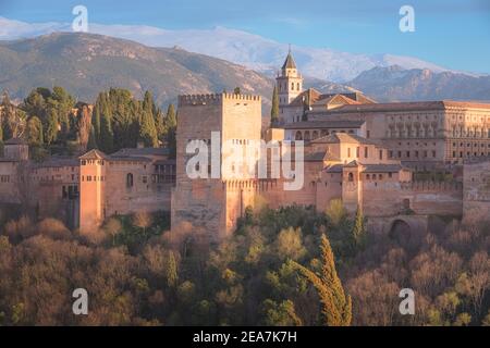 Vue classique avec coucher de soleil lumière dorée sur le Palais Charles V, l'Alhambra emblématique et les montagnes de la Sierra Nevada depuis Mirador de San Nicolas dans l'albaicin Banque D'Images