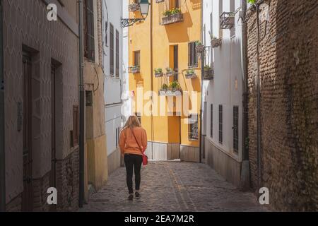 Une jeune femme blonde touriste explorant l'étroite rue pavée de la vieille ville (Albaicin ou quartier arabe) à Grenade, Andalousie, Espagne. Banque D'Images