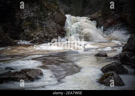 Chute d'eau gelée dans la forêt norvégienne. Rivière Homla en Norvège. Temps froid et gelé en hiver. Neige et glace dans les bois. Cascade de Mettifossen. Banque D'Images