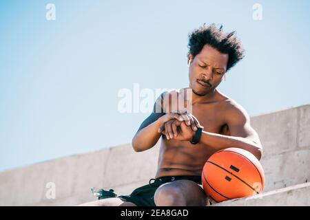 Homme de fitness vérifiant l'heure sur la montre intelligente. Banque D'Images