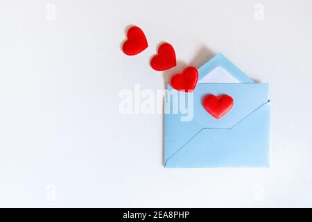 Cœur rouge volant de la lettre d'amour dans une enveloppe bleue sur fond blanc. Lettre d'amour avec coeurs et espace de copie. Gratitude aux médecins et aux infirmières. Soupape Banque D'Images