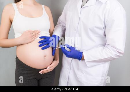 Concept de la famille du nouveau-né. Une femme enceinte avec la main d'un médecin pour vacciner, infirmière vaccinant la jeune fille ayant un enfant ou un jeune en développement dans le TH Banque D'Images