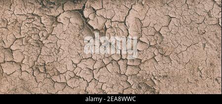 Arrière-plan de la terre sèche brune fissurée de la terre ou de la terre pendant la sécheresse. Terre fissurée sèche représentant des conditions de sécheresse graves. Panorama Banque D'Images