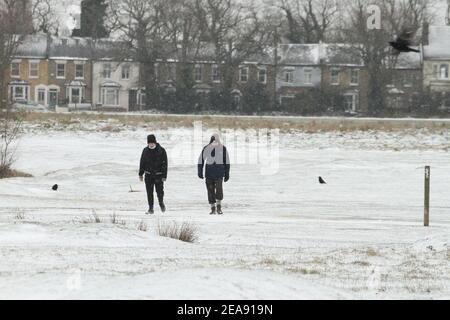 Les gens marchent à travers un parc Wanstead couvert de neige à Redbridge. De fortes chutes de neige et de glace ont perturbé certaines parties du Royaume-Uni, Londres recevant environ 5 cm de neige. Les vents forts de l'est de la tempête Darcy ont plongé les températures dans certaines parties du Royaume-Uni en dessous de moins un. Banque D'Images