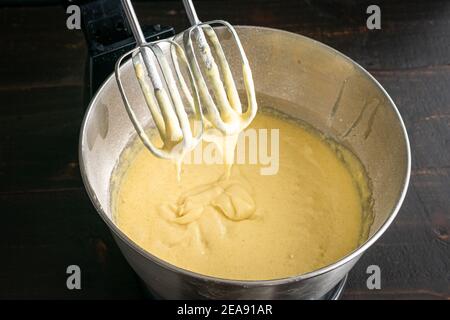 Gros plan des batteurs sur socle dans la pâte à gâteau au-dessus de la vanille : pâte à gâteau qui a été mélangée dans un bol de mixeur sur socle électrique Banque D'Images