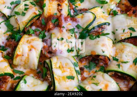 Courettes de courgettes aux champignons dans une poêle en fonte : courgettes garnies d'un mélange de fromages italiens, de champignons et de sauce tomate Banque D'Images