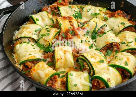 Courettes de courgettes aux champignons dans une poêle en fonte : courgettes garnies d'un mélange de fromages italiens, de champignons et de sauce tomate Banque D'Images