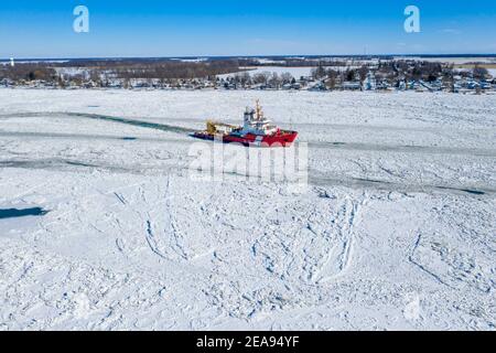 Roberts Landing, Michigan, États-Unis. 7 février 2021. Le brise-glace de la Garde côtière canadienne Samuel Risley brise la glace sur la rivière St. clair. Le froid amer a entraîné des embâcles sur la rivière et des inondations dans les communautés riveraines. La rivière Sainte-Claire est la frontière entre les États-Unis et le Canada; elle draine les Grands Lacs supérieurs vers le lac Sainte-Claire et le lac Érié. Crédit : Jim West/Alay Live News Banque D'Images