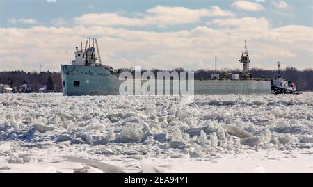 Roberts Landing, Michigan, États-Unis. 7 février 2021. Le Challenger de St Marys navigue sur la glace sur la rivière St. clair, avec l'aide de brise-glace américains et canadiens (non illustré). Construit en 1906 en tant que porte-minerai automoteur, le St. Marys Challenger a été converti en barge poussée par un remorqueur. Crédit : Jim West/Alay Live News Banque D'Images