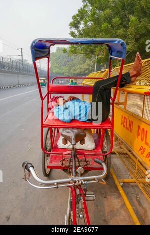 Pousse-pousse avec chauffeur endormi à Delhi, Inde Banque D'Images