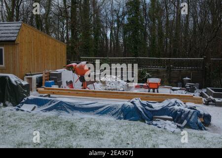 Matériaux et machines de construction couverts de neige sur un site de construction à Rural Devon, Angleterre, Royaume-Uni Banque D'Images