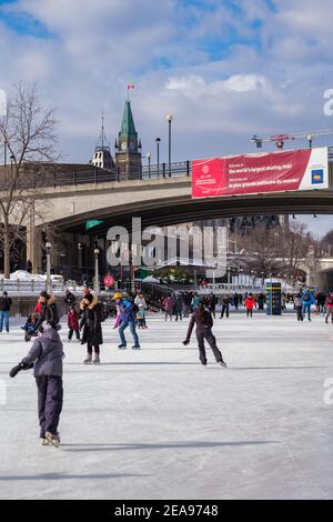 Ottawa (Ontario), Canada - le 6 février 2021 : les résidents d'Ottawa apprécient le patinage sur glace sur la patinoire du canal Rideau sous une bannière de la CCN annonçant la res Banque D'Images