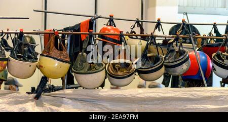 Vieux casques de moto accrochés à une tige lors d'un salon pour les véhicules classiques à Tulln, Autriche Banque D'Images