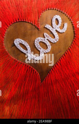 Concept de Saint-Valentin. Mot amour sur fond rouge. Carte rouge vierge avec le coeur et le mot Amour sur fond rouge pour vos salutations. Façonner le cœur Banque D'Images