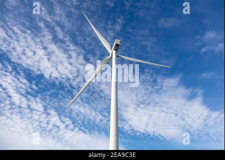 Éolienne sur fond bleu ciel nuageux, vue aérienne de drone, concept de génération d'énergie alternative, écoindustrie renouvelable verte Banque D'Images