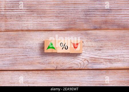 Bloc cube en bois avec symbole de pourcentage d'icône et flèche vers le haut et le bas. Concept d'affaires de taux d'intérêt, financier, de classement et de taux hypothécaires. Banque D'Images