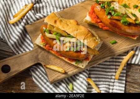 Sandwich à la saucisse merguez frites maison avec Harrisa on a Bun Banque D'Images