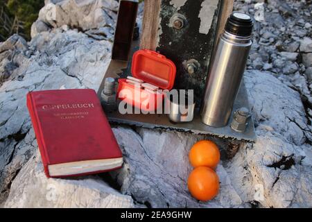 Gamseck au-dessus de la cabane Mittenwalder, Croix du souvenir, livre de sommet, snack, thermos, oranges Banque D'Images