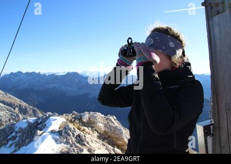 Randonnée jusqu'à la Pléisenspitze (2569m), jeune femme au sommet avec vue à travers des jumelles, excursion en montagne, randonnée en montagne, en plein air Banque D'Images