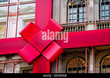 Énorme ruban rouge avec noeud sur l'extérieur d'un Bâtiment avec lumières de Noël à Londres Banque D'Images