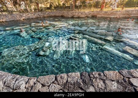 08 septembre 2020, Pamukkale, Turquie: Ancienne piscine avec sources thermales et vestiges de colonnes est un endroit populaire pour les touristes à se détendre après la marche Banque D'Images