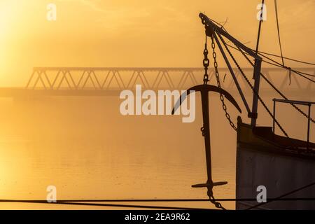 L'ancre du bateau à aubes Kaiser Wilhelm en silhouette au lever du soleil avec le pont Elbe de Lauenburg / Elbe, Schleswig-Holstein en arrière-plan Banque D'Images