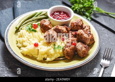 Boulettes de viande suédoises avec purée de pommes de terre et haricots verts sur le noir arrière-plan en pierre Banque D'Images