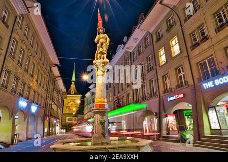 Berne, Suisse - 23 août 2020 : scène urbaine nocturne de la fontaine Marksman ou Schutzenbrunnen sur la rue du marché Marktgasse et la tour de l'horloge Zytglogge Banque D'Images